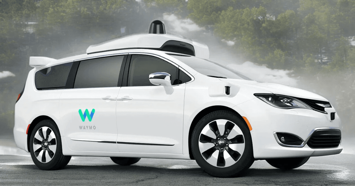 A white Waymo self-driving minivan equipped with sensors and autonomous driving technology, parked on a road with a misty forest backdrop. The vehicle represents real-life agentic systems in autonomous transportation.