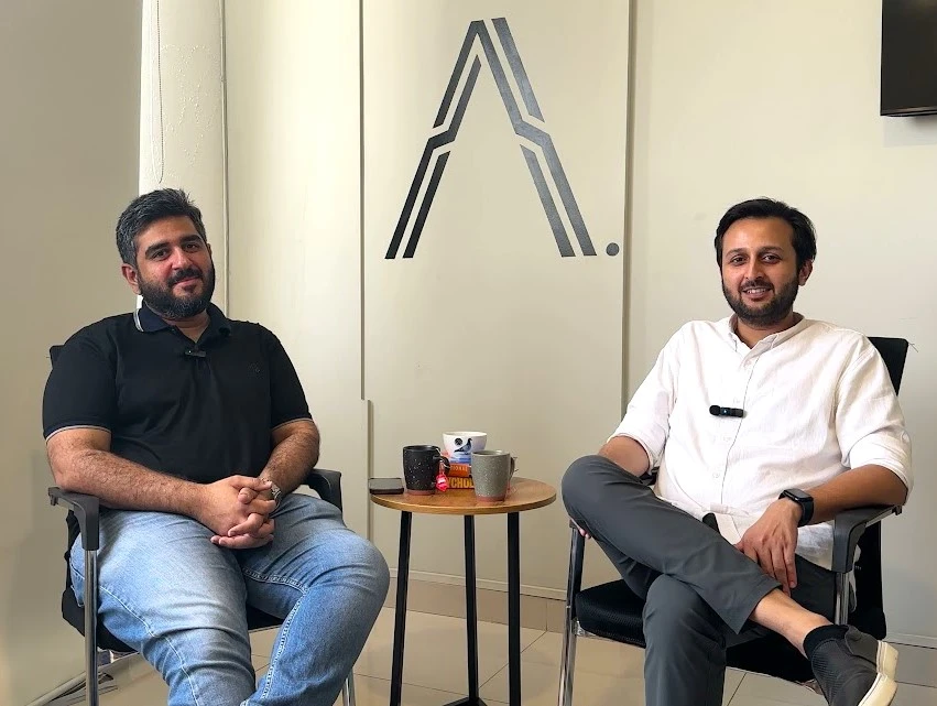 Our founders seated in chairs, with Autonomous logo visible on the wall.