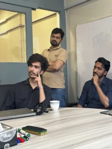 A close-up shot of three male team members focused and deep in thought during an intense meeting or presentation, conveying concentration and engagement within the team.